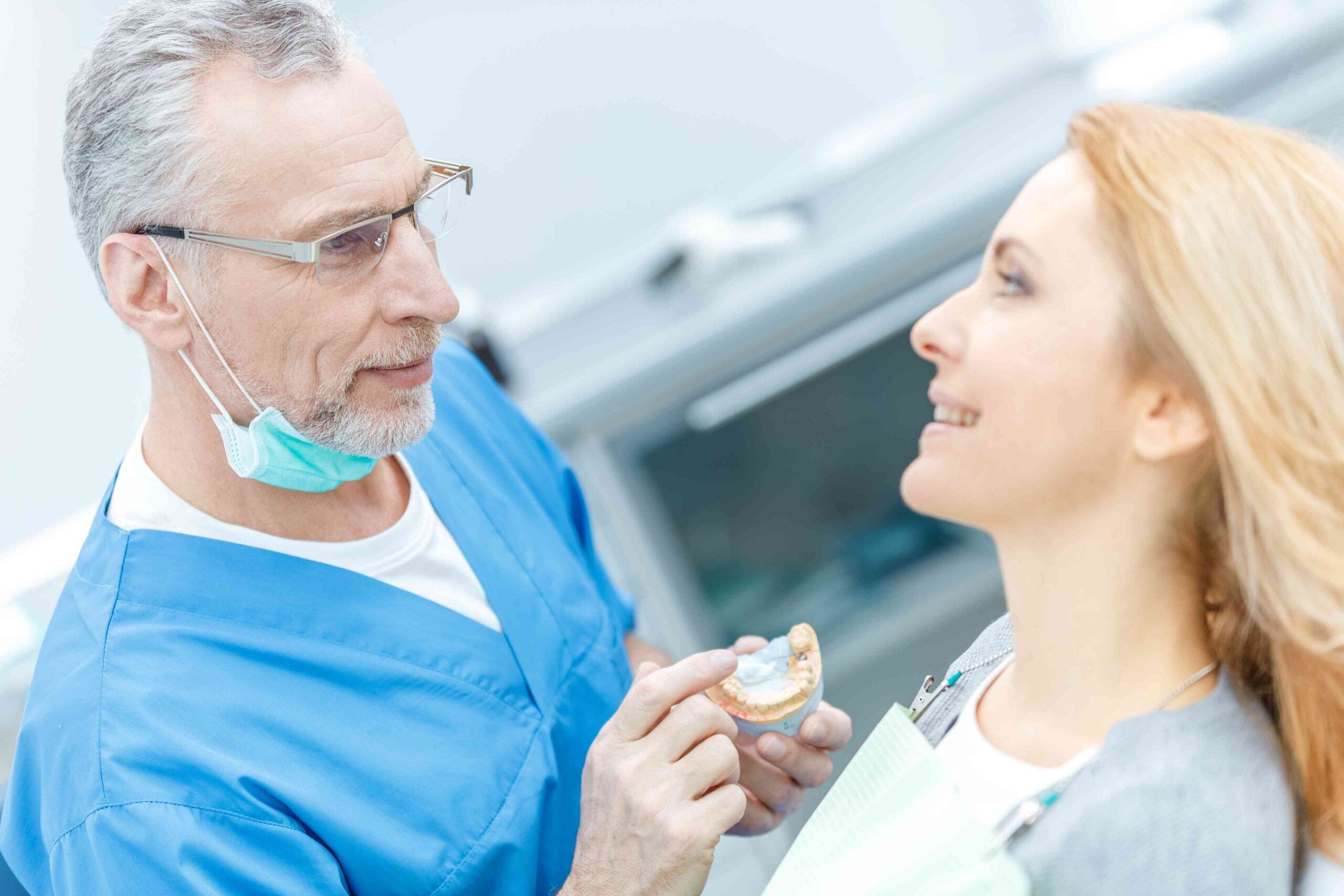 lasting-oral-health-dental-care-cornelius Dentist explaining a dental implant treatment plan to a patient using a dental model