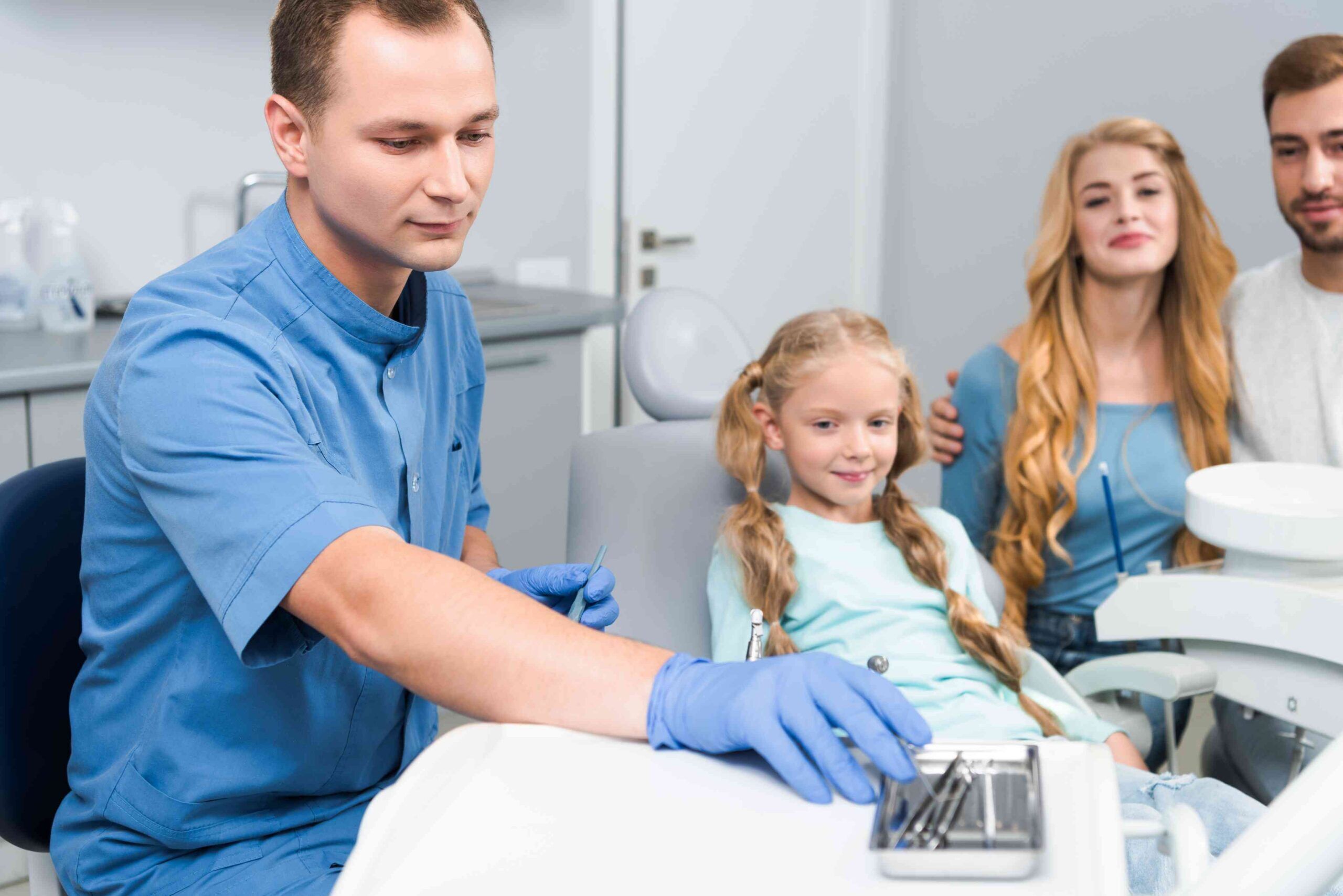 Parents supporting their child during a dental clinic visit.