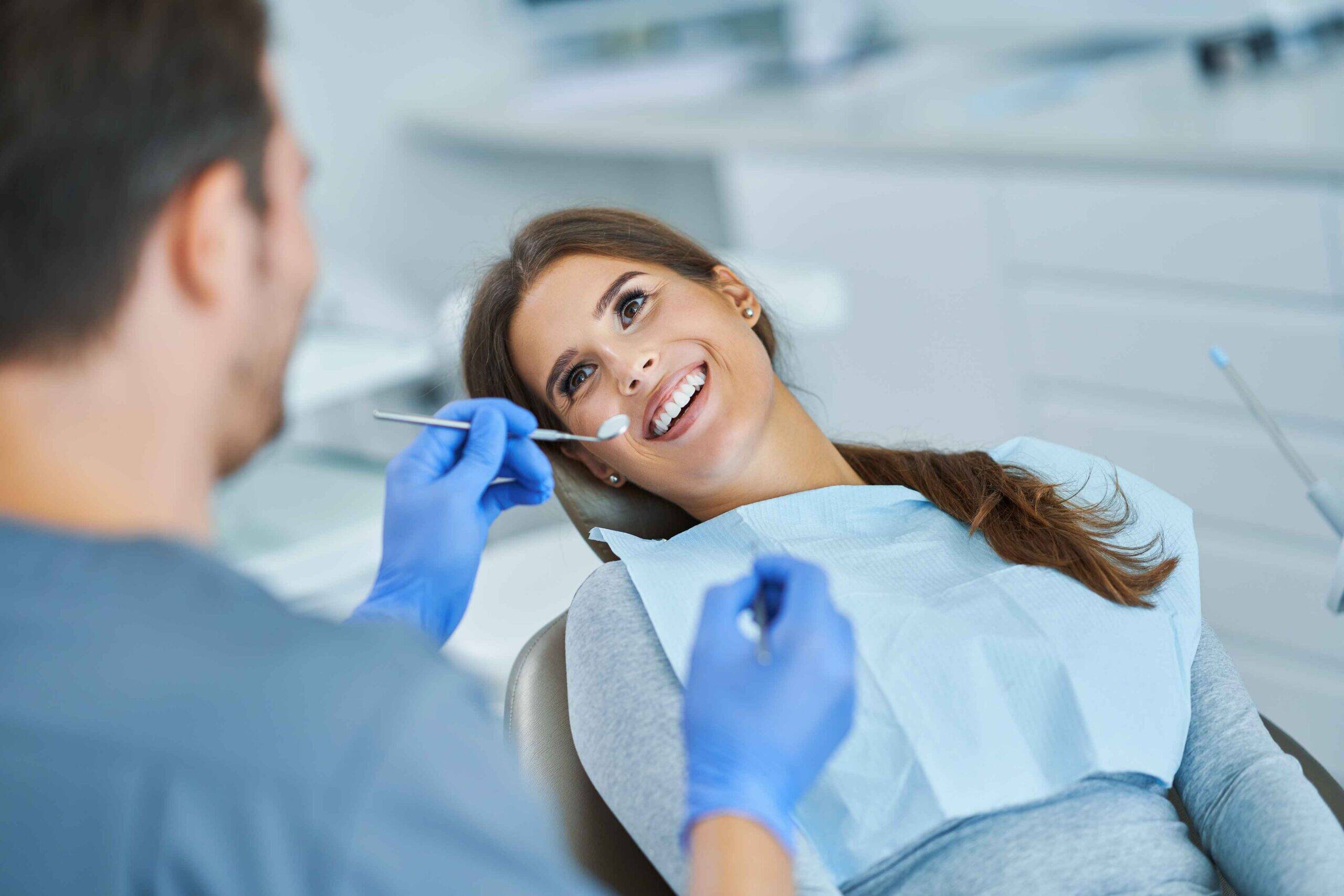 dental-crown-damaged-tooth Dentist examining a smiling patient during a dental checkup.