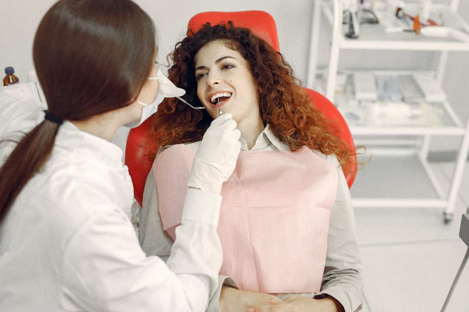beautiful-girl-sitting-dentist-s-office Dentist examining a patient during a dental checkup